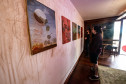 Homem observando obras da mostra Paisagens Distópicas