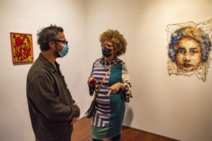 A artista Claudia Lara discute sua obra com Lavalle, professor do MCAA