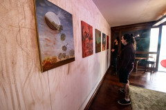 Homem observando obras da mostra Paisagens Distópicas